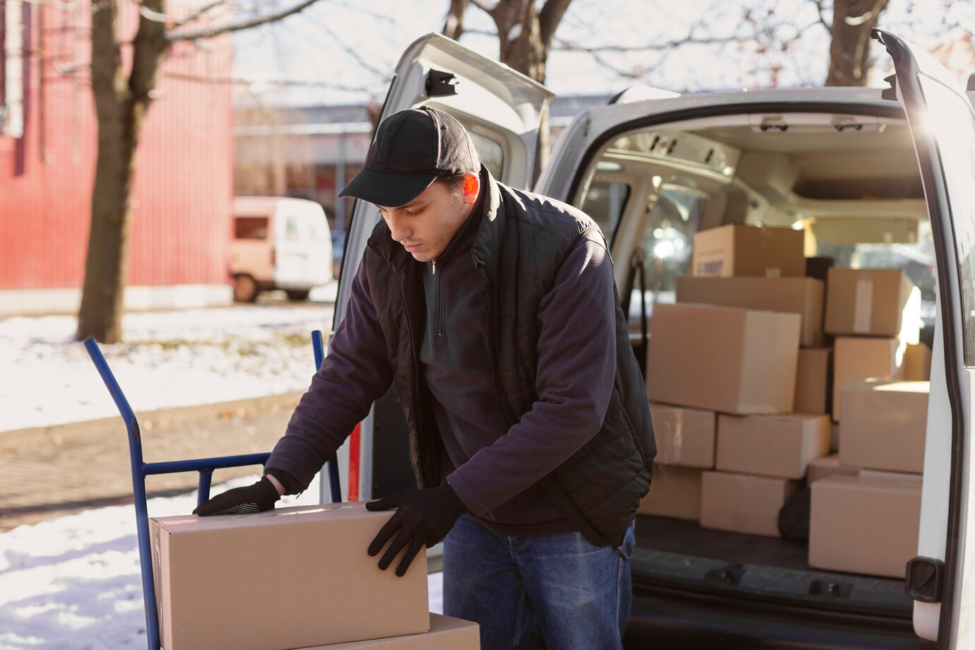 Person Loading Cardboard Boxes Into A Van